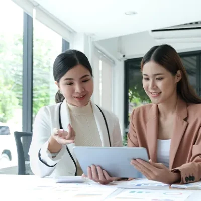 two-beautiful-young-asian-businesswoman-working-together-using-digital-tablet-office